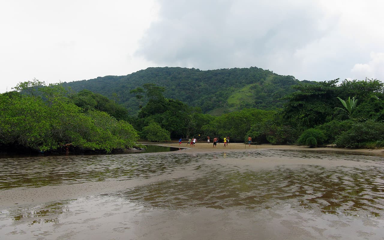 The Itamambuca river meeting the sea, with forest-covered hills behind.